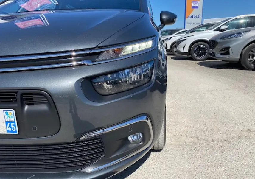 Gros plan sur l'avant droit d'une Citroën C4 Picasso gris shark avec phares LED et calandre chromée.