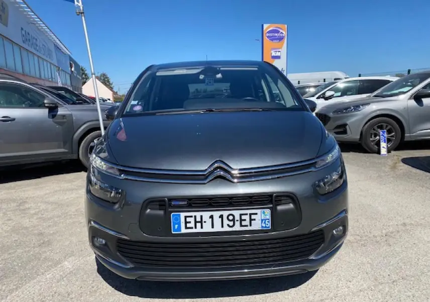 Vue avant d'une Citroën C4 Picasso gris shark 2016 avec calandre chromée et phares LED allumés.