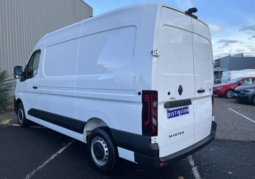 Renault Master blanc en vue 3/4 arrière droit, fourgon tôlé avec feux arrière verticaux et jantes tôle.