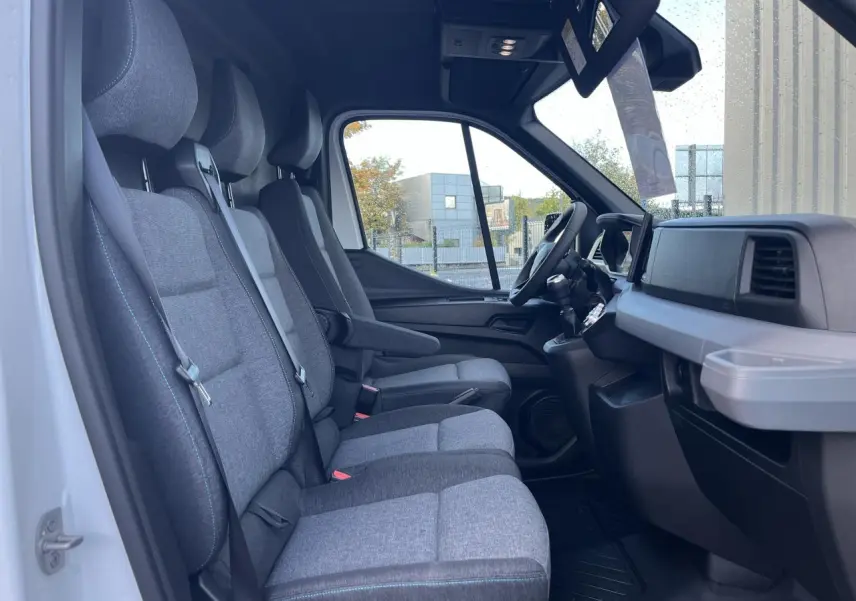 Intérieur du Renault Master blanc vu côté gauche, montrant les sièges tissu gris chiné et tableau de bord noir.