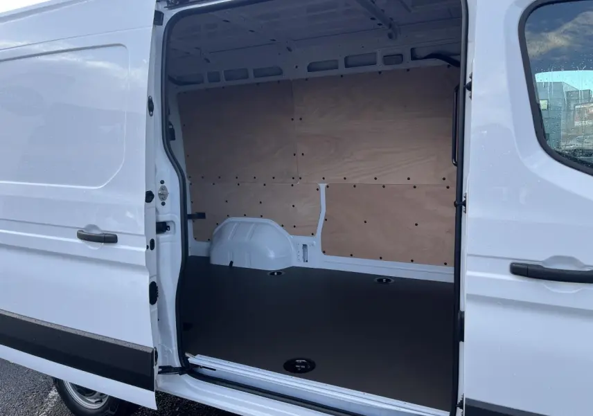 Vue latérale droite du Renault Master blanc 2025 avec porte coulissante ouverte montrant l'intérieur aménagé en plancher bois.