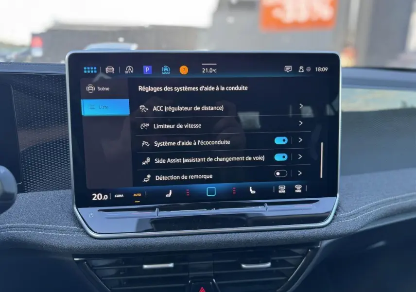 Écran tactile central affichant les réglages d'aide à la conduite dans une Volkswagen Passat SW noire 2024.