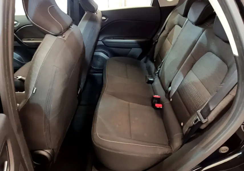Vue intérieure côté droit sur la banquette arrière noire du Renault Captur Business TCe 90 2021 avec ceinture et appuie-tête.