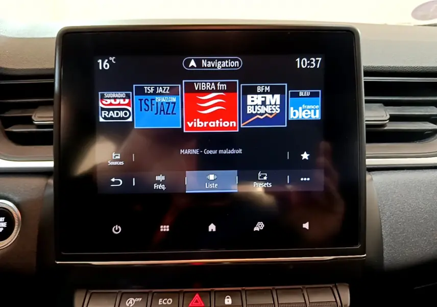 Écran tactile central du tableau de bord du Renault Captur Business noir, affichant les stations radio et la navigation.