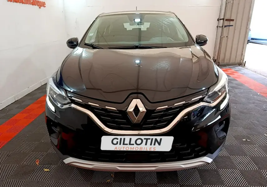 Vue de face du Renault Captur Business TCe 90 noir, mettant en valeur sa calandre chromée et ses phares LED allumés.