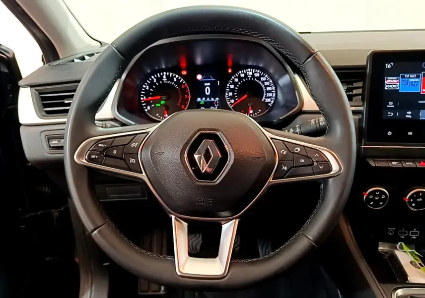 Vue rapprochée du volant noir de la Renault Captur Business 2021 avec tableau de bord et écran tactile visible à droite.