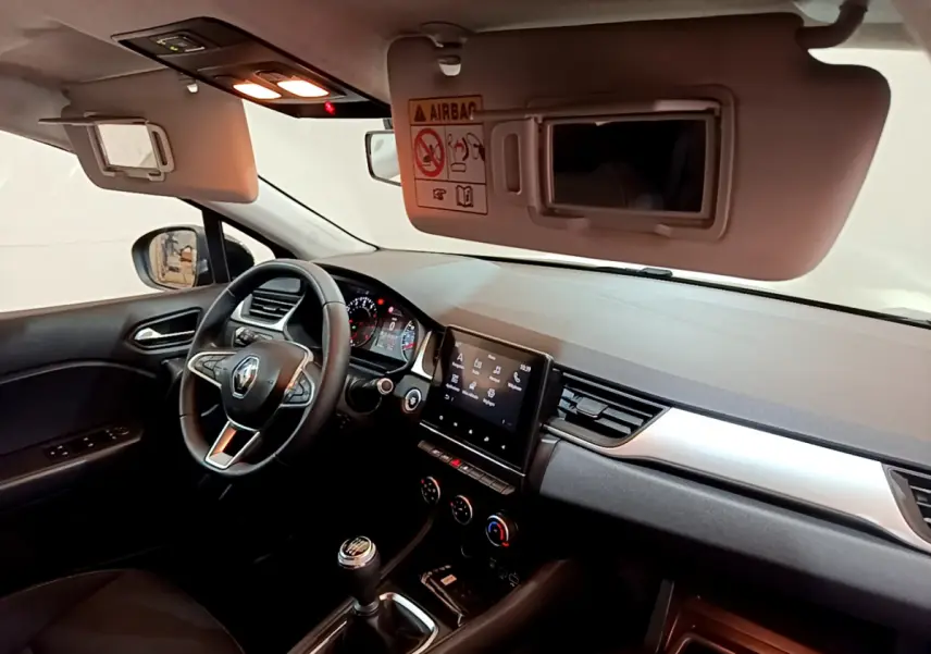 Intérieur du Renault Captur Business TCe 90 2021 vu côté conducteur, tableau de bord avec écran tactile et volant noir.