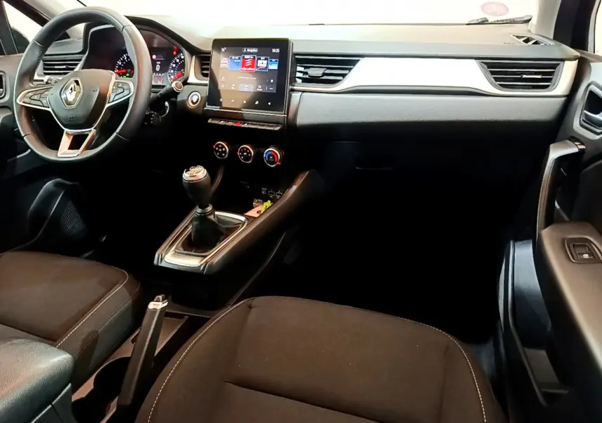 Vue intérieure côté conducteur du tableau de bord noir du Renault Captur Business TCe 90 avec écran tactile et boîte manuelle.