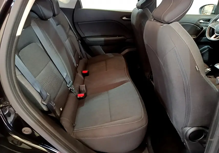 Vue intérieure côté gauche des sièges arrière noirs du Renault Captur Business TCe 90 de 2021 avec ceintures visibles.