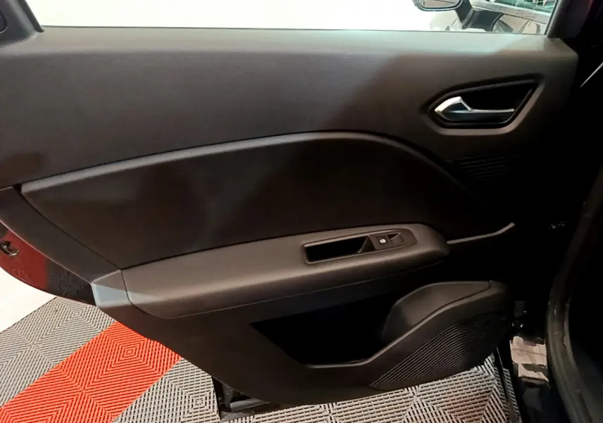 Intérieur noir de la porte côté droit du Renault Captur Business TCe 90 2021 avec poignée et commandes de vitre.