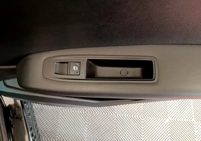 Gros plan sur la commande de lève-vitre côté gauche de la porte d’une Renault Captur Business TCe 90 noire de 2021.