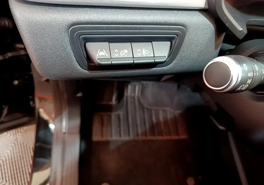 Gros plan sur les commandes d'assistance à la conduite sous le tableau de bord du Renault Captur noir 2021.