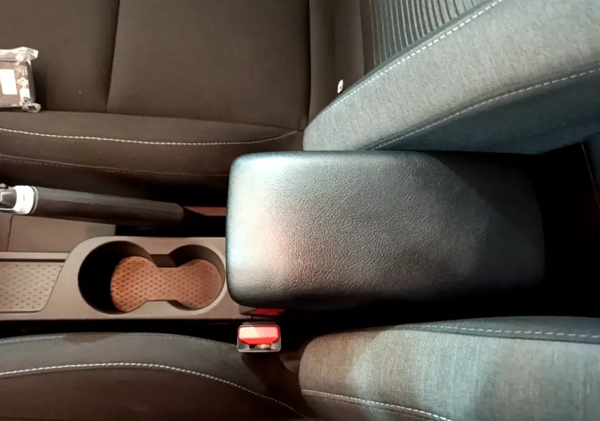 Vue plongeante sur l'accoudoir central noir et les sièges en tissu gris du Renault Captur Business TCe 90 2021.