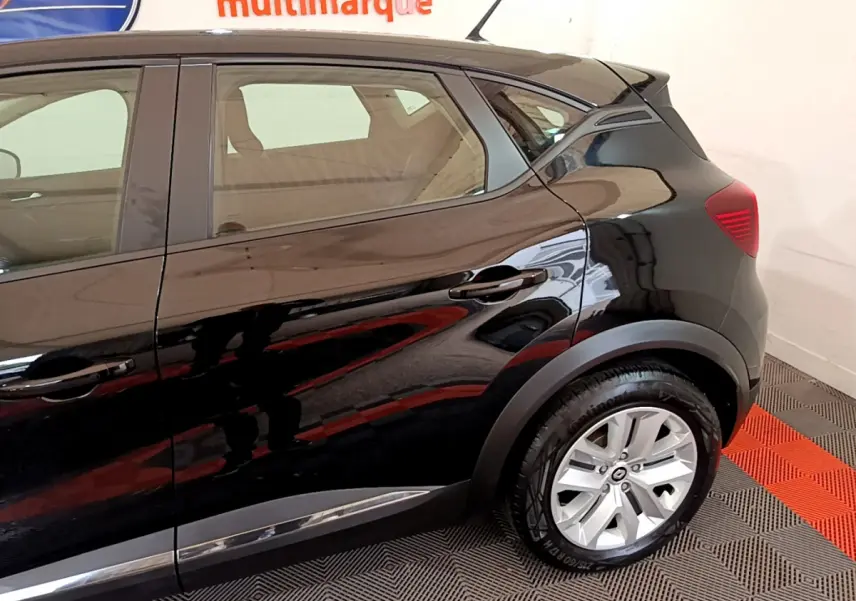 Profil côté droit du Renault Captur Business noir brillant, mettant en valeur la roue arrière et les lignes fluides du SUV.