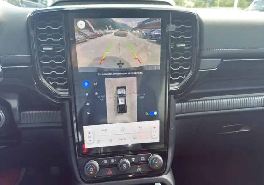 Vue rapprochée de l'écran central tactile du Ford Ranger 2025 noir agate montrant la caméra de recul et les commandes climatisation.
