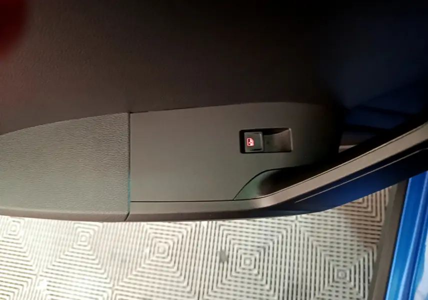 Gros plan sur le bouton de verrouillage des portes côté gauche d’une SEAT Arona bleu 2022, intérieur voiture.