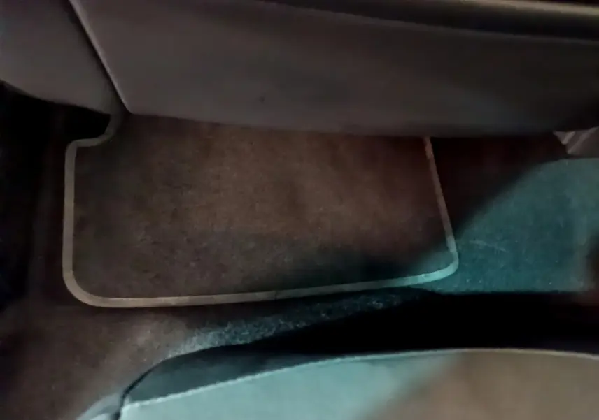 Vue rapprochée du tapis de sol marron sous le siège passager arrière d’un SEAT Arona bleu 2022.