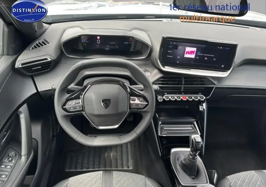 Vue intérieure avant du Peugeot 2008 1.2 100 Allure 2025, volant multifonction, écran tactile et levier de boîte manuelle.