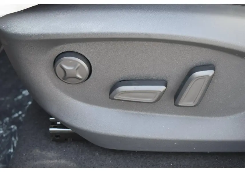 Gros plan sur les commandes électriques du siège conducteur du MG Motor EHS blanc 2026, finition Luxury.