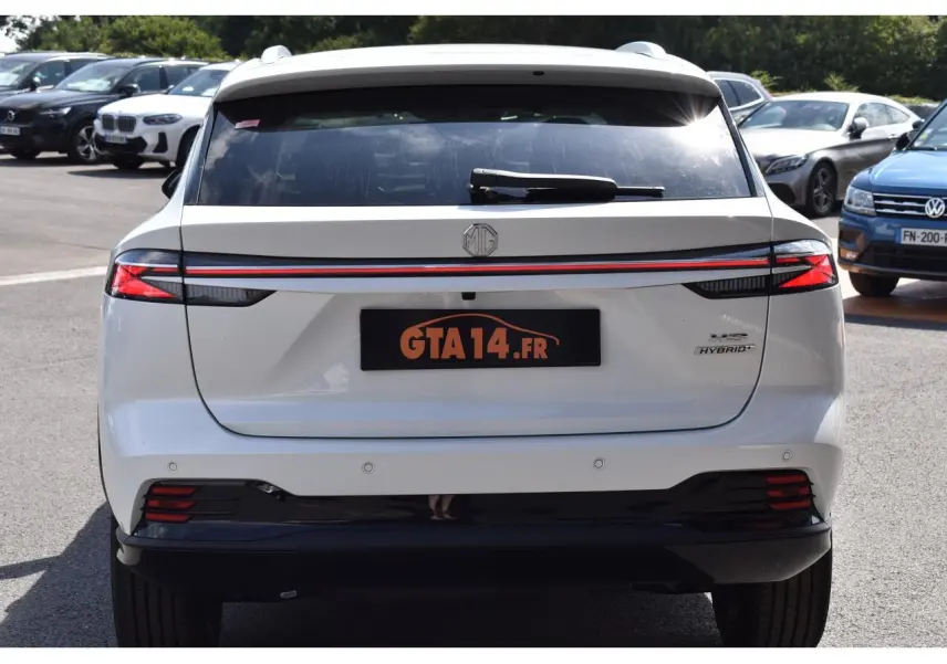 Vue arrière d'un MG MOTOR EHS blanc 1.5 Hybrid+ 224 ch Luxury avec feux LED et bande lumineuse rouge continue.