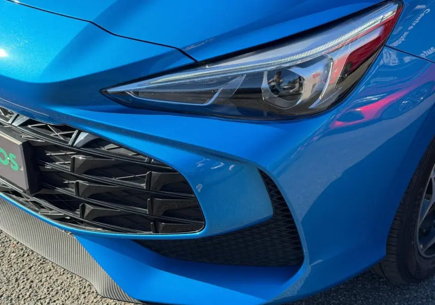 Gros plan sur l'avant droit bleu Como métallisé du MG3 1.5 Hybrid+ 195ch avec phares et calandre distinctifs.