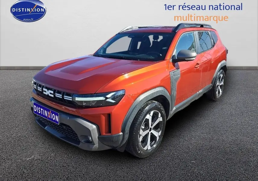 Dacia Duster 2025 brun terracotta en 3/4 avant droit avec barres de toit et jantes alu distinctives