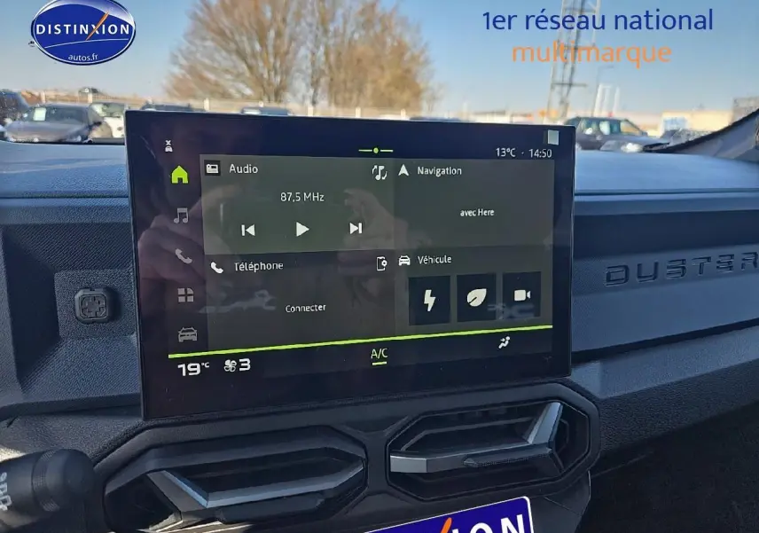 Écran tactile central du tableau de bord du Dacia Duster 2025, ambiance intérieure moderne et épurée.