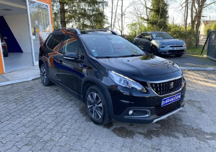 Peugeot 2008 noir métallisé vue 3/4 avant droit avec jantes aluminium 16 pouces et calandre distinctive.
