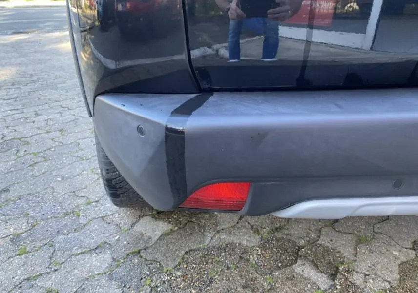 Gros plan sur le coin arrière gauche noir métallisé du Peugeot 2008 2019 avec feu rouge et pare-chocs gris.