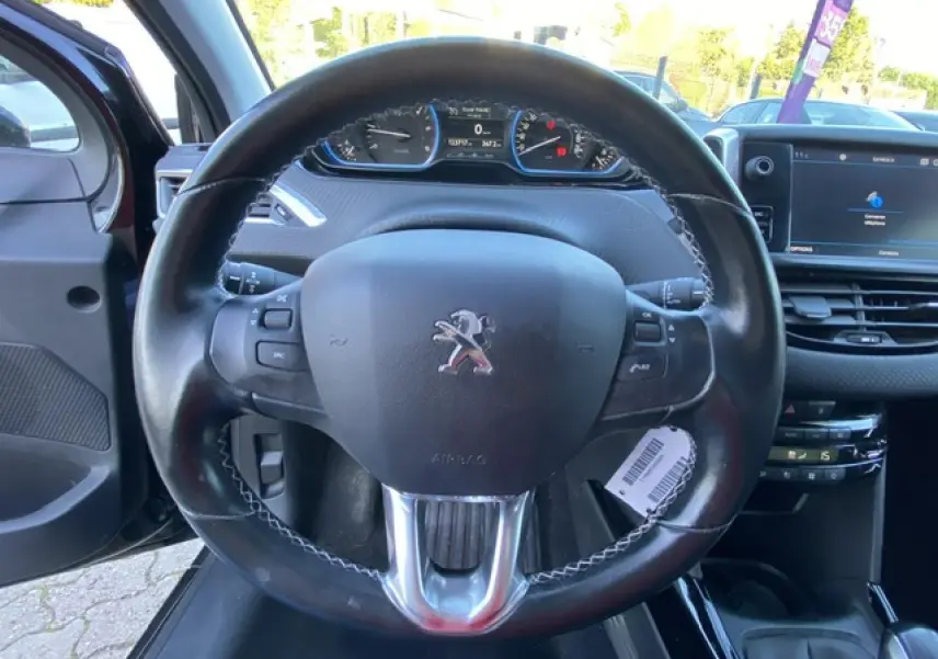 Vue rapprochée du volant cuir noir du Peugeot 2008 2019 avec tableau de bord et écran tactile visible.
