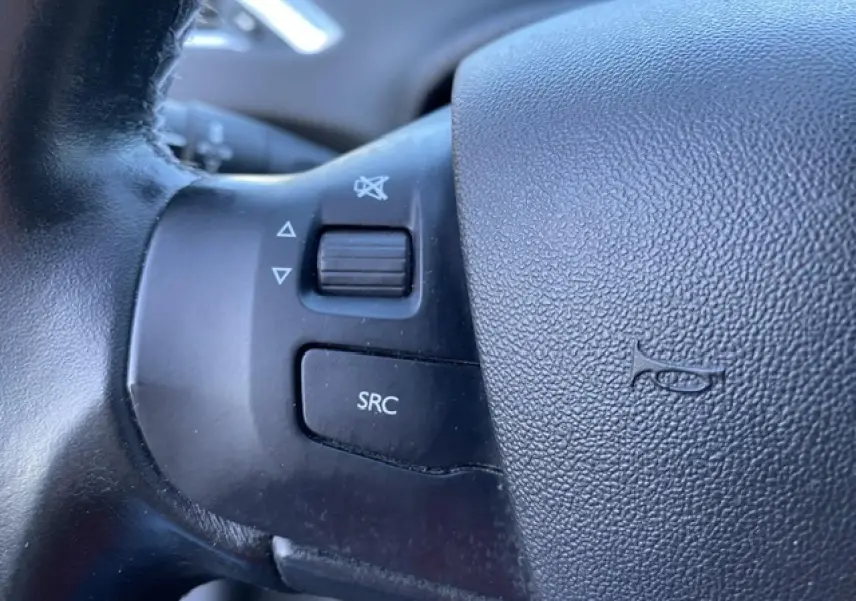 Gros plan sur les commandes audio au volant noir du Peugeot 2008 2019 version Allure diesel.