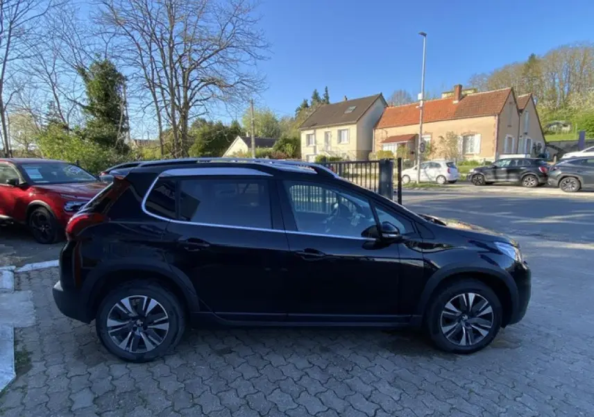 Profil côté gauche d'un Peugeot 2008 noir métallisé de 2019 avec jantes aluminium 16 pouces diamantées.