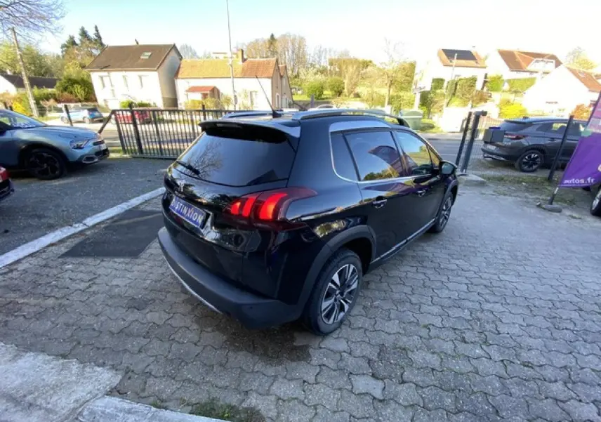 Peugeot 2008 noire vue en 3/4 arrière droit, avec jantes aluminium diamantées et vitres teintées.