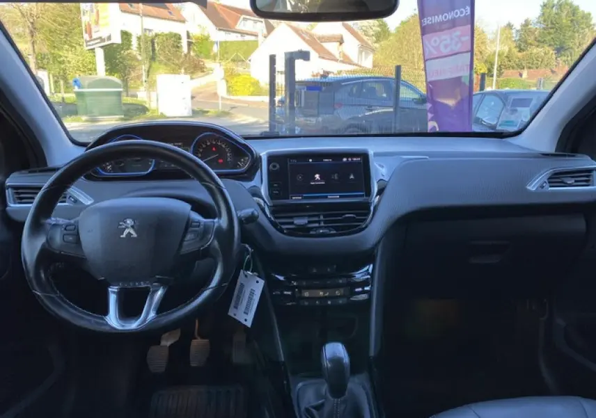Intérieur noir du Peugeot 2008 2019, vue frontale sur le tableau de bord avec écran tactile et volant multifonction.
