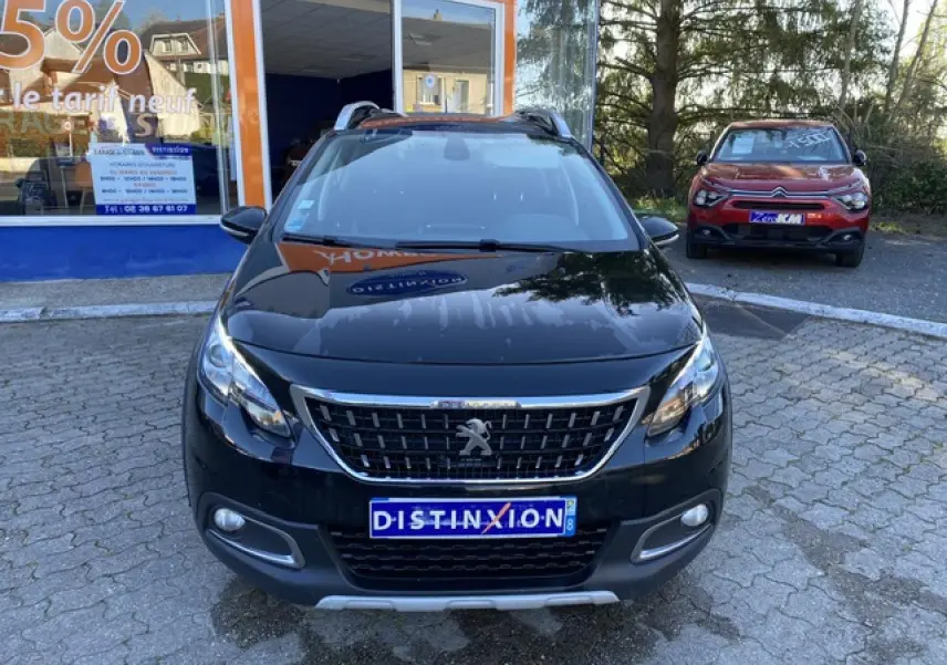 Peugeot 2008 noir métallisé vue de face, avec calandre chromée et plaques d'immatriculation Distinxion visibles.