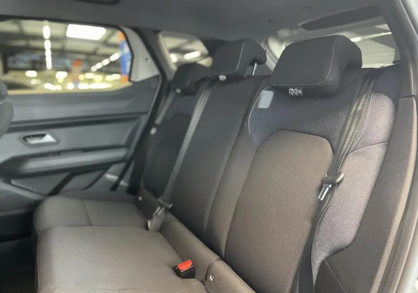 Vue intérieure côté droit sur la banquette arrière noire du Dacia Duster 2025, finition Denim avec ceintures de sécurité.
