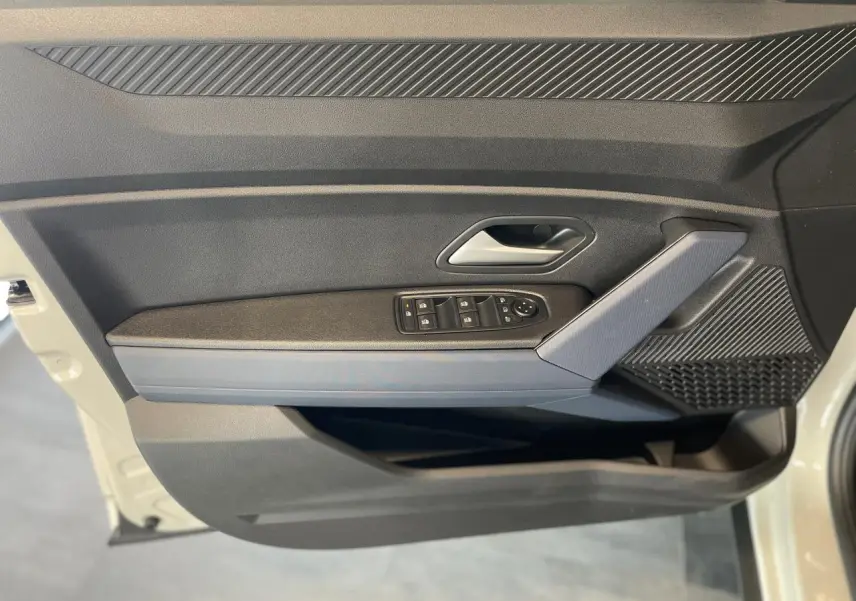 Porte côté gauche du Dacia Duster 2025 beige, avec commandes de vitres électriques et accoudoir Denim Bleu.