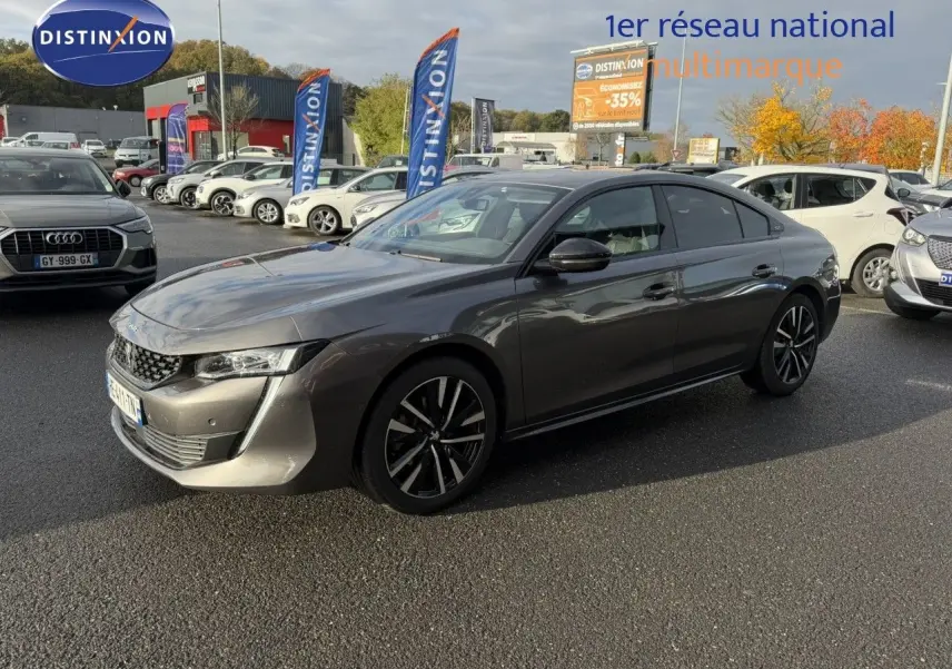 Peugeot 508 gris platinium en 3/4 avant droit, mettant en valeur ses lignes élégantes et ses jantes noires.