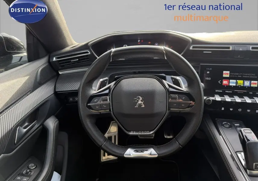 Vue intérieure centrée sur le volant GT de la Peugeot 508 gris platinium avec tableau de bord numérique et console moderne.