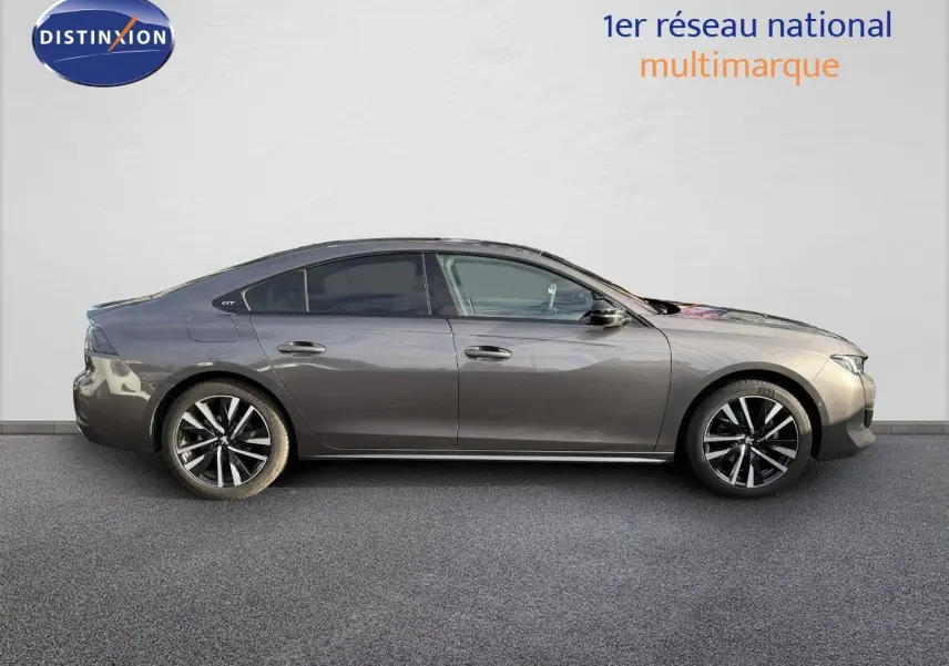 Profil droit d'une Peugeot 508 II GT gris platinium de 2023, soulignant ses jantes alliage et lignes élégantes.