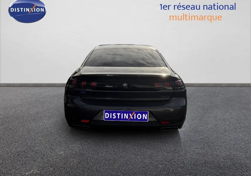 Vue arrière d'une Peugeot 508 gris platinium de 2023 avec feux arrière à griffes et plaque Distinxion.