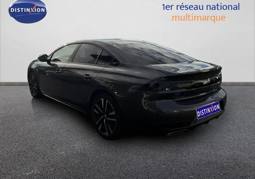 Peugeot 508 gris platinium vue 3/4 arrière droit, avec feux arrière noirs et jantes alliage distinctives.