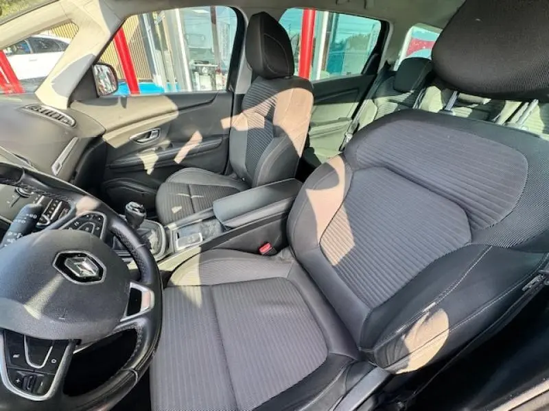 Vue intérieure côté conducteur du Renault Grand Scenic 2019, sièges tissu carbone foncé embossé et volant cuir.