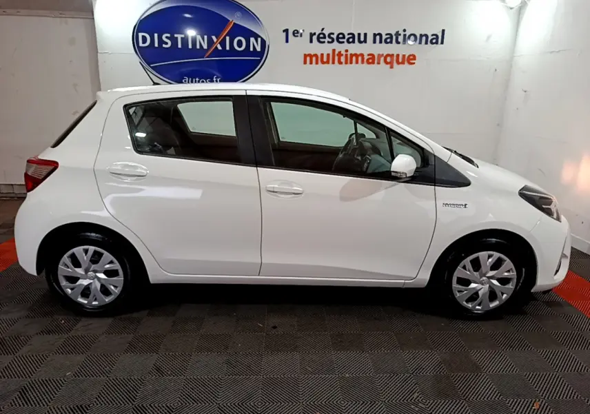 Profil droit de la Toyota Yaris 1.5 Hybride blanche de 2020, avec logo hybride visible sur l'aile avant.
