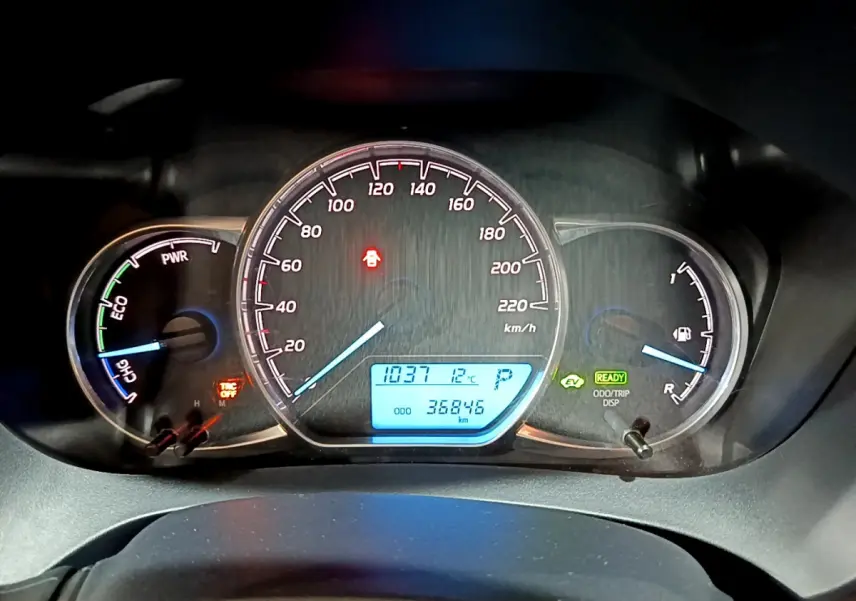 Tableau de bord de Toyota Yaris hybride 2020 avec compte-tours, vitesse, jauge essence et affichage digital bleu.