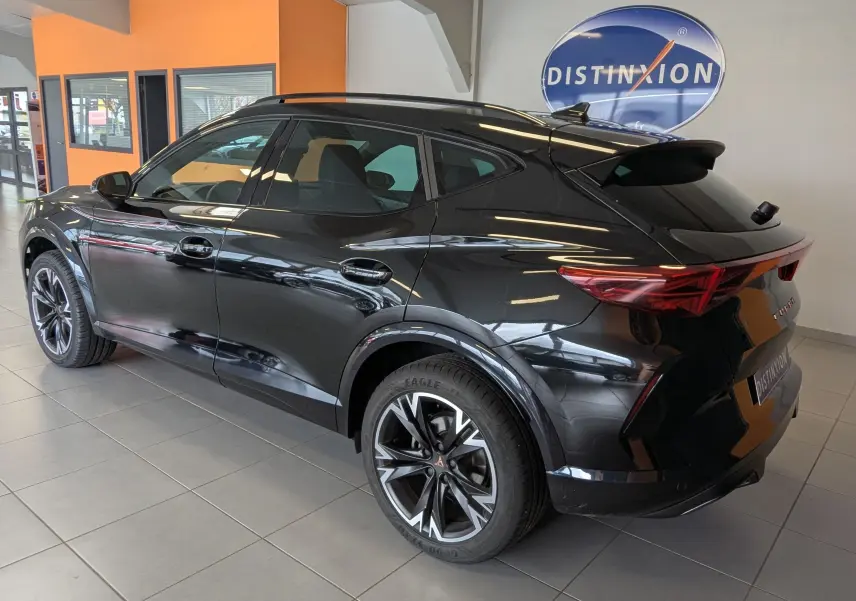 Vue 3/4 arrière droite d’un CUPRA Formentor gris magnétique avec jantes alliage 18'' TEMPEST en showroom.