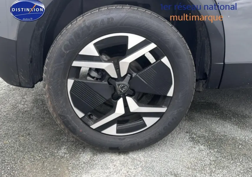 Gros plan sur la roue avant droite du Peugeot 2008 gris sélénite avec jante alu au design moderne.