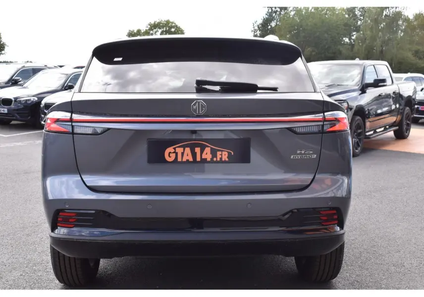Vue arrière d'un MG Motor EHS gris 2026 avec feux LED reliés par une bande lumineuse rouge et logo MG central.