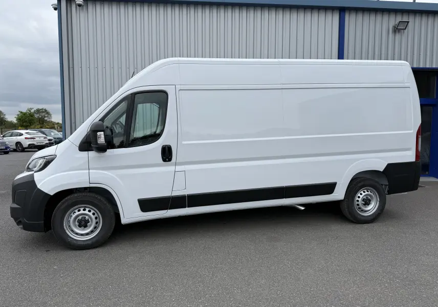 Vue latérale gauche d'un utilitaire blanc Citroën Jumper FGN L3H2 2025 avec protections noires et jantes acier.