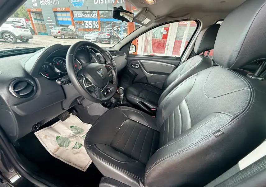 Intérieur avant du Dacia Duster 2017 noir métal, sièges cuir noir et volant multifonctions visible côté conducteur.